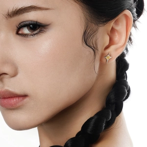Star-shaped S925 sterling silver studs with gold center shown on a female model
