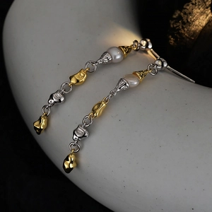 Baroque pearl earrings in mixed gold and silver tones with irregular textured metal design