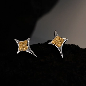 Dual-tone starburst stud earrings in S925 sterling silver on a dark mineral background