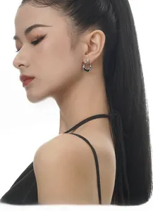 Vue rapprochée d'un modèle portant une boucle d'oreille créole torsadée en argent