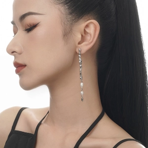 Textured sterling silver wavy earrings with three white freshwater pearls on model