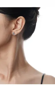 Close-up of a model wearing a small S925 sterling silver crescent moon earring with crystals