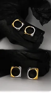 Macro shot of S925 sterling silver square hoop earrings with gold-silver color blocking