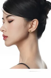 Macro side view of a model wearing the delicate gold crescent moon stud earring with gems