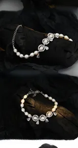 Macro detail of S925 silver baroque pearl bracelet with floral charms and zircon droplets