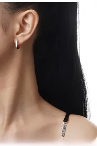 Close-up of minimalist S925 sterling silver hoop earring on model showing sleek metal texture