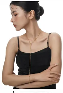 Collana lunga a Y con perline dorate e chiusura a sfera regolabile indossata da modella