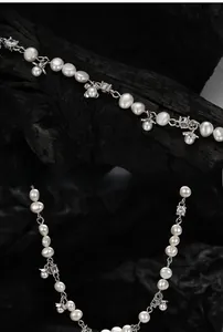 Macro shot of S925 silver flower necklace with irregular baroque pearls on black wood