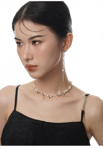 Detail of S925 silver flower necklace and long pearl tassel earrings on a model