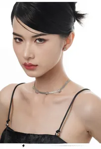 Macro shot of silver mesh choker and matching geometric earrings on a model