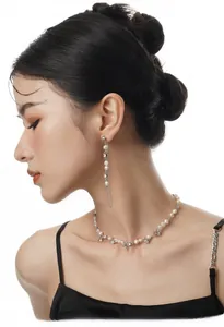 Close-up of elegant S925 silver long tassel pearl earrings and matching necklace on a model