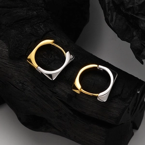 Two-tone geometric square hoop earrings in gold and silver finish on dark stone