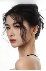 Vue détaillée de boucles d'oreilles spirales dorées avec perles sur un mannequin