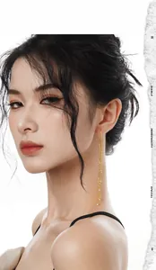 Close-up of elegant gold long tassel earrings with sparkling rhinestones on a female model