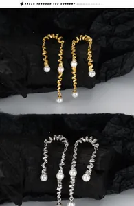 Vue détaillée de boucles d'oreilles spirales torsadées avec perles blanches et dorées