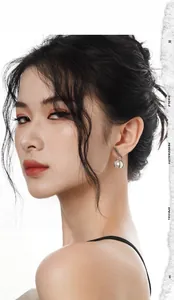 Close-up of elegant S925 silver leaf earrings with glossy pearl drop on a model