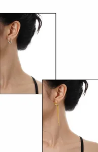 Detail of S925 silver U-shaped earrings with long gold tassel fringe on white background