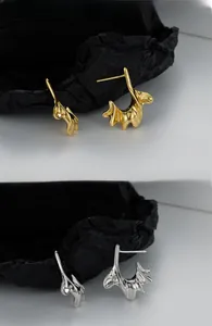 Detail shot of irregular molten S925 sterling silver C-shape stud earrings in gold and silver