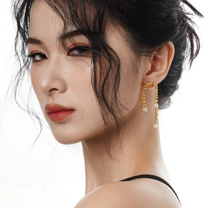 Élégantes boucles d'oreilles spirales dorées avec perles blanches sur mannequin