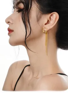 Side view of a woman wearing gold S925 sterling silver U-shaped tassel drop earrings