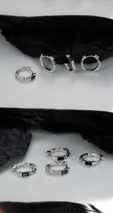 Detail of S925 sterling silver hoop earrings with textured finish and emerald green stone