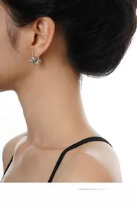 Close-up of silver irregular lava texture C-shape earrings worn on a model side profile