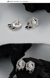 Macro shot of S925 sterling silver hexagonal stud earrings with black tassel details