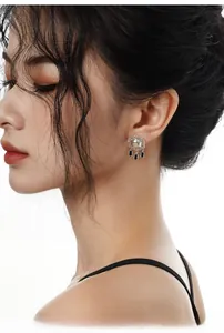 Detail of ethnic S925 silver star stud earrings with black tassel and crystal inlay
