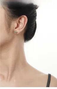 Macro view of S925 silver liquid metal earring with a green stone on a model's ear