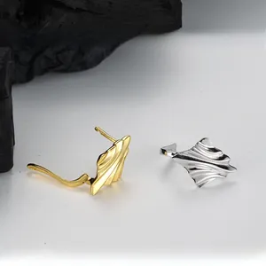 Macro detail of S925 sterling silver wave earrings with irregular textured surface