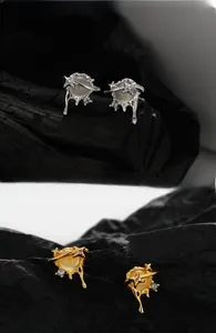 Detail of S925 silver and gold Saturn earrings with liquid metal and cat-eye stones