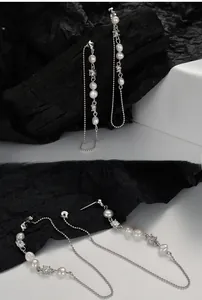 Macro shot of silver tassel earrings with white pearls and sparkling crystals on display