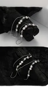 Detailed macro view of S925 sterling silver tassel earrings with baroque pearls and zircons