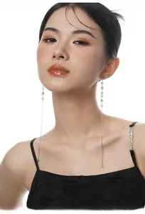 Model wearing elegant S925 sterling silver tassel earrings with baroque pearls and rhinestones