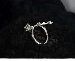 Detail of S925 sterling silver rose ring with thorn-like band on charcoal background
