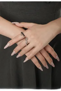 Detail of S925 silver rose ring and black pavé diamond band worn on a hand