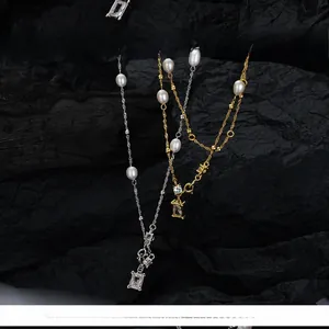 Detail of baroque pearl necklaces with rectangular zircon pendants on black stone