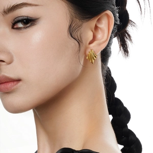 Minimalist S925 sterling silver golden wavy earrings worn by a model in a side view profile