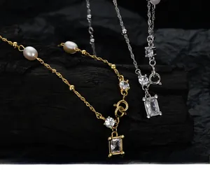 Detailed close-up of gold and silver necklaces with baroque pearls and zircon pendants