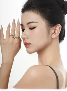 Detailed view of silver rose-shaped ear cuffs with sparkling diamonds and twig texture