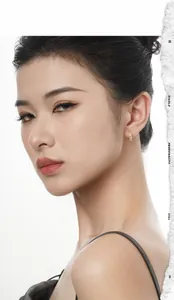 Close-up of elegant gold huggie earrings with cubic zirconia stones on a model