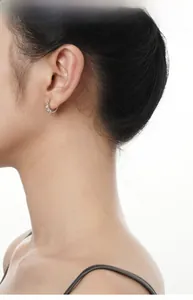 Close-up of S925 sterling silver huggie earrings with textured pavé diamond detail