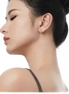 Macro detail of silver pavé hoop earring with sparkling stones on model's ear