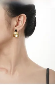 Gros plan de boucles d'oreilles géométriques en argent doré avec incrustation d'émail