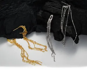 Macro shot of S925 sterling silver long tassel chain earrings in gold and silver
