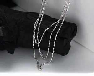 Détail du collier multicouche en argent fin S925 sur support en bois de style vintage