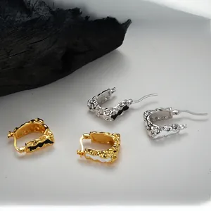 Vue macro des boucles d'oreilles en argent S925 avec texture lave et émail bicolore