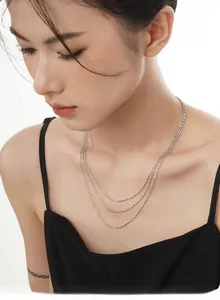 Gros plan d'un collier triple couche en argent S925 porté par un mannequin chic