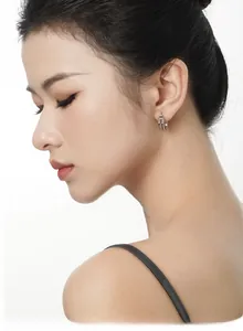 Side view of woman wearing geometric double-layered S925 sterling silver hoop earrings