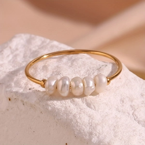 Detailed view of five natural freshwater pearls set on a gold stainless steel band